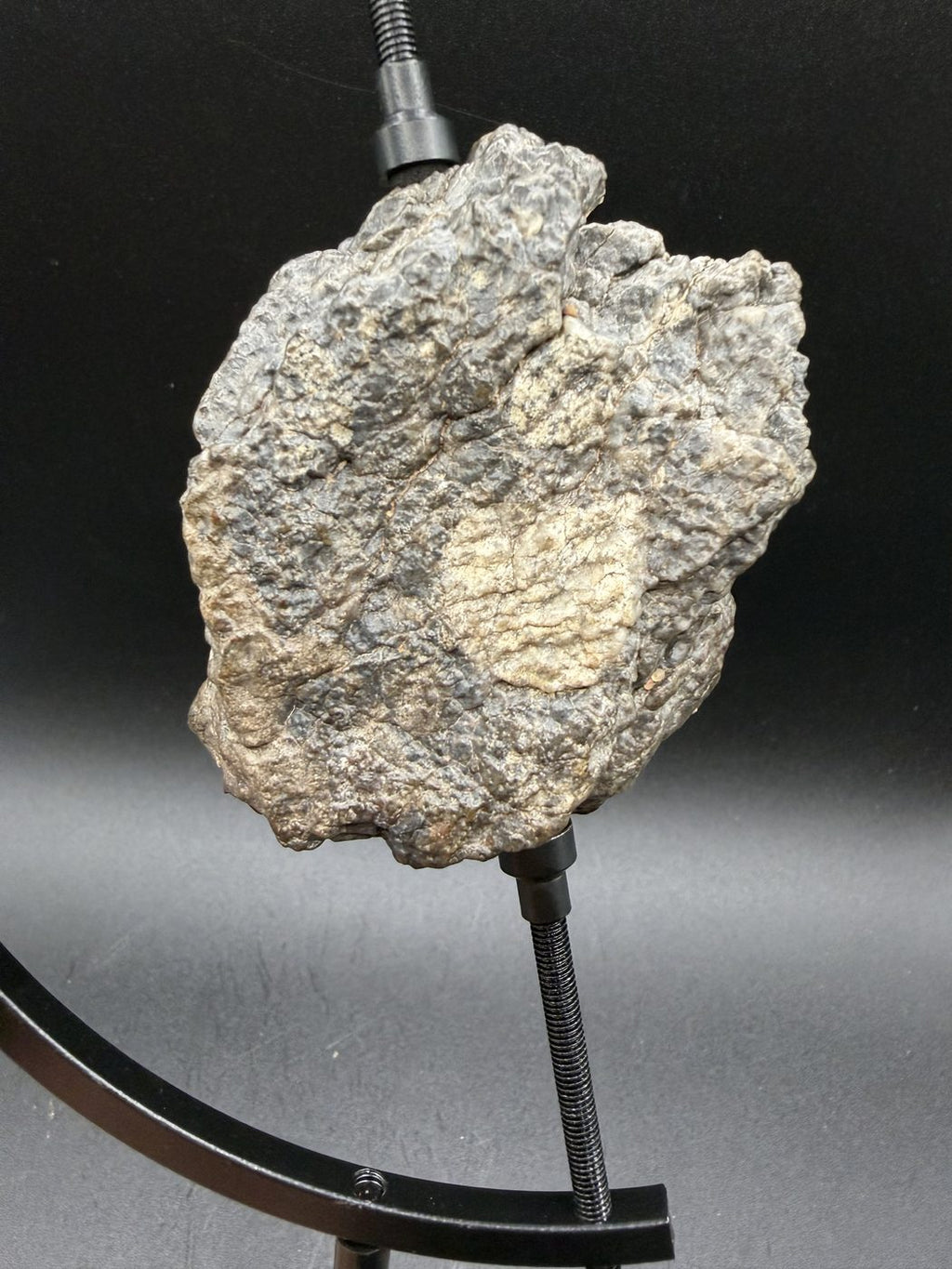 The 193.73g Laâyoune 002 lunar feldspathic breccia mounted on a display stand
