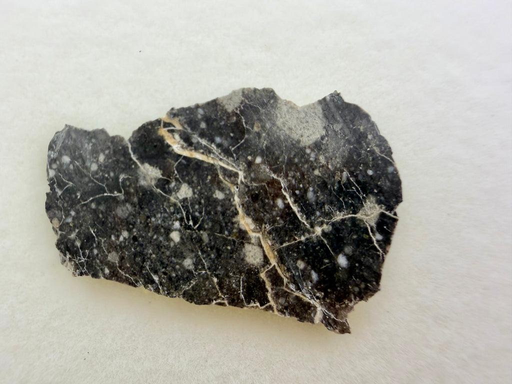 Rabt Sbayta 007 lunar meteorite 1.58g -- angular plagioclase clasts and impact-mixed matrix in complete cross-section