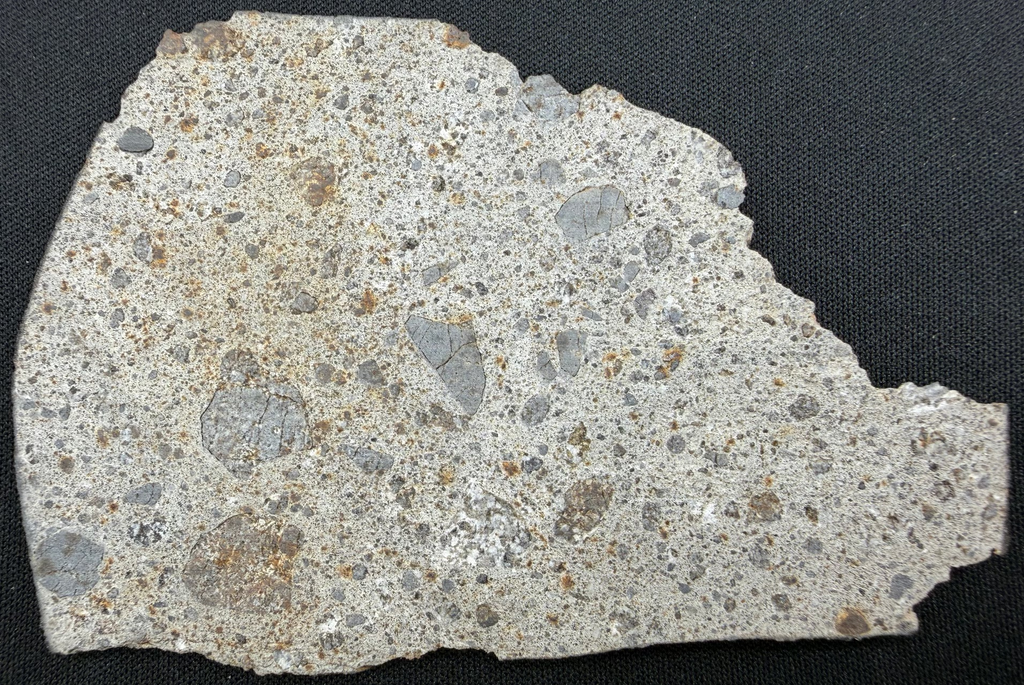 NWA 17708 howardite 38.73g -- rippling fusion crust preserved along edge surface showing atmospheric entry heating texture