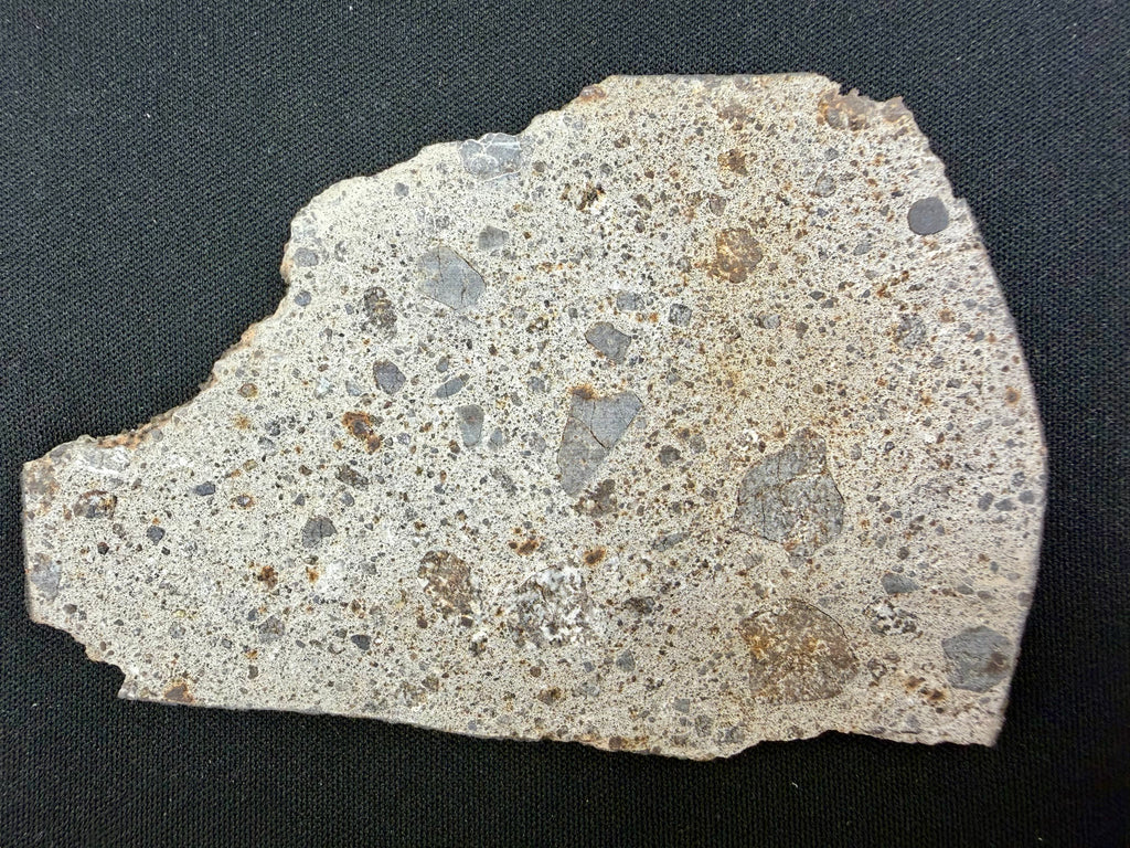 NWA 17708 howardite 36.92g -- rippled black fusion crust showing atmospheric entry ablation texture on edge surface