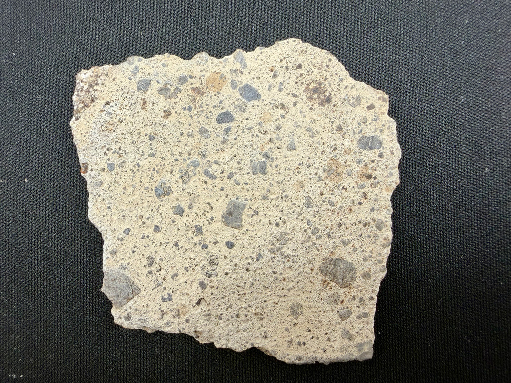 NWA 17708 howardite 21.31g -- fresh rippled fusion crust covering edge surface with dark vitreous texture