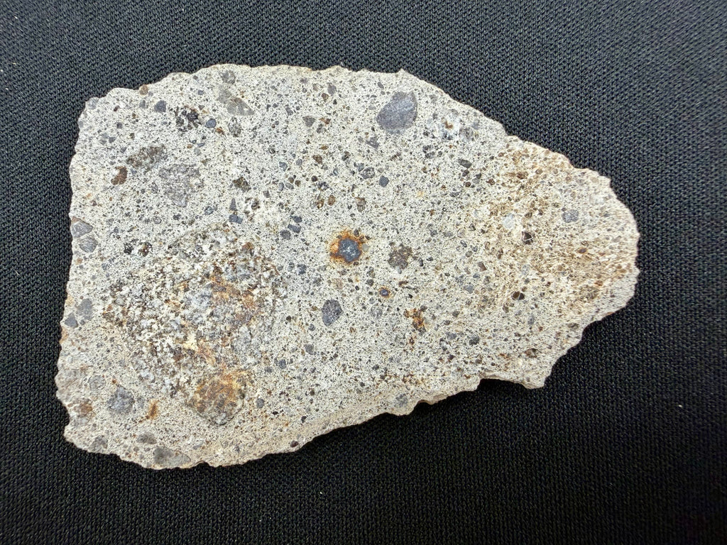 NWA 17708 howardite 29.12g -- rippled fusion crust texture showing atmospheric ablation patterns along edge surface