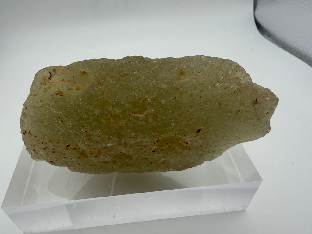 Libyan Desert Glass impactite 178.68g -- transmitted light view revealing flow banding and internal bubble structures