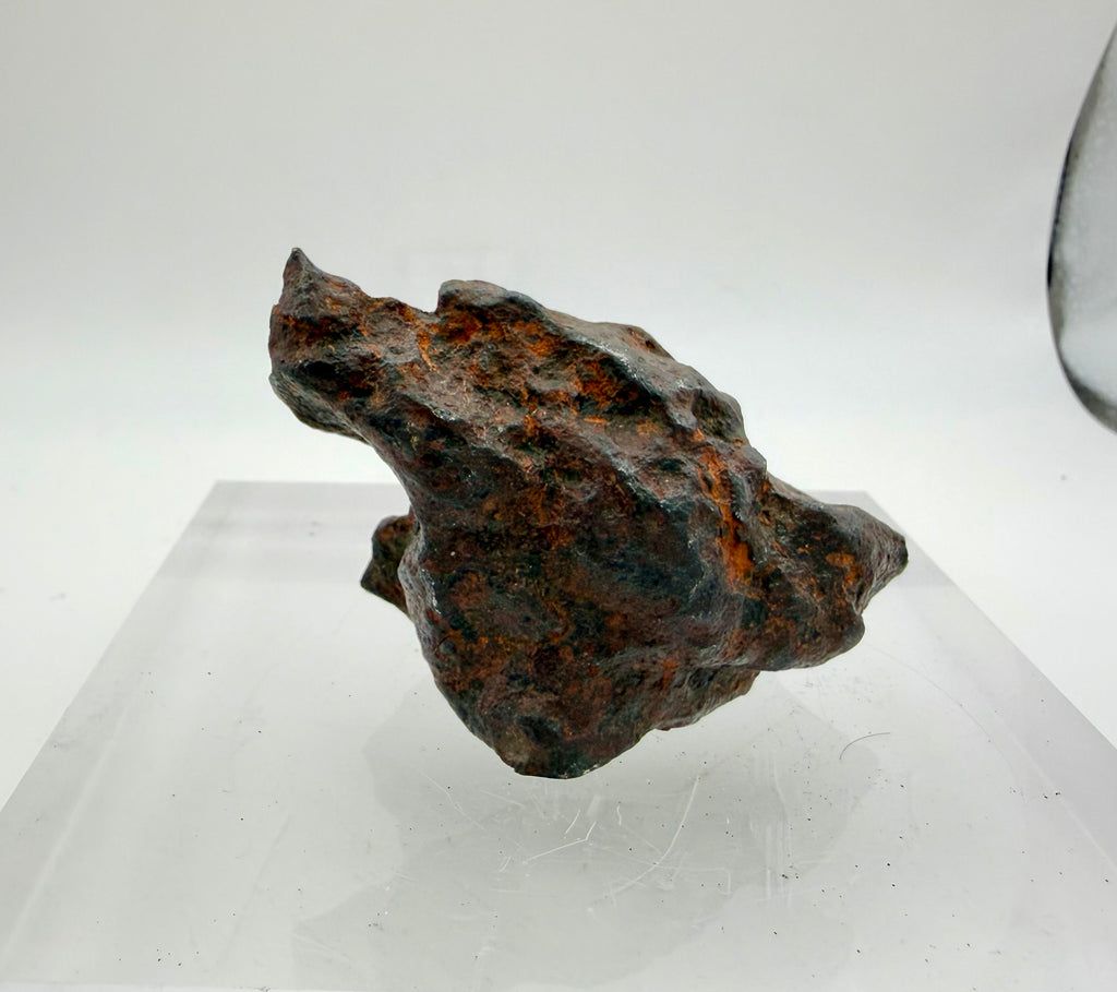 Gebel Kamil meteorite 216.06g -- transition between oxidized exterior patina and bright polished metallic interior