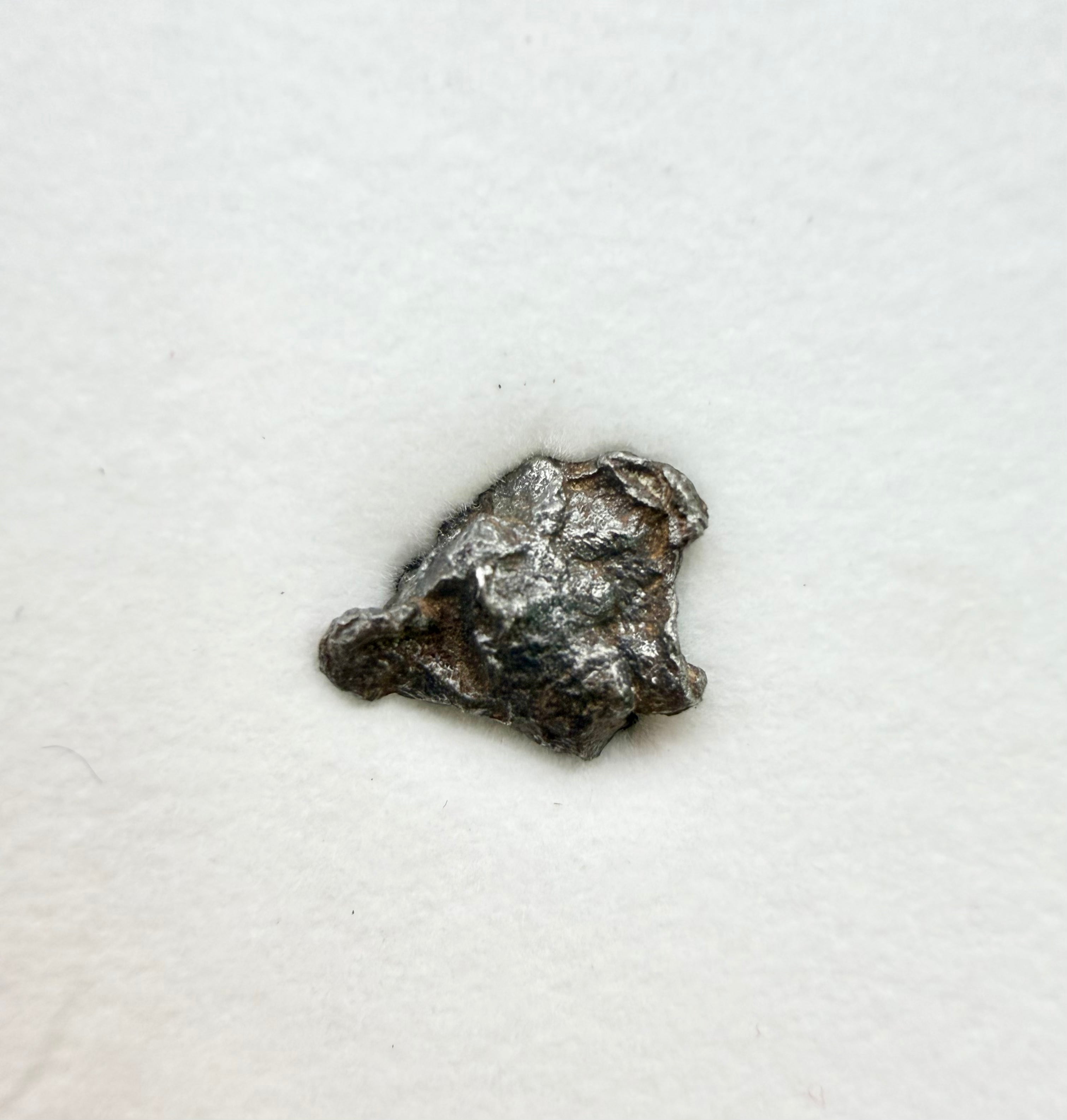 Gebel Kamil meteorite 1.00g -- close view of metallic iron surface texture from Egyptian desert impact site