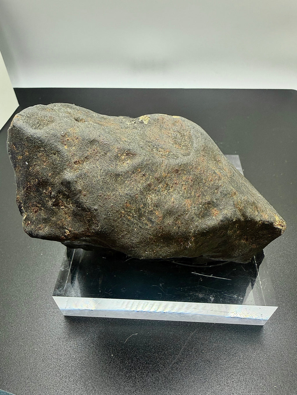 NWA XXX chondrite individual 1091.71g -- fusion crust detail showing glassy black coating and flow lines