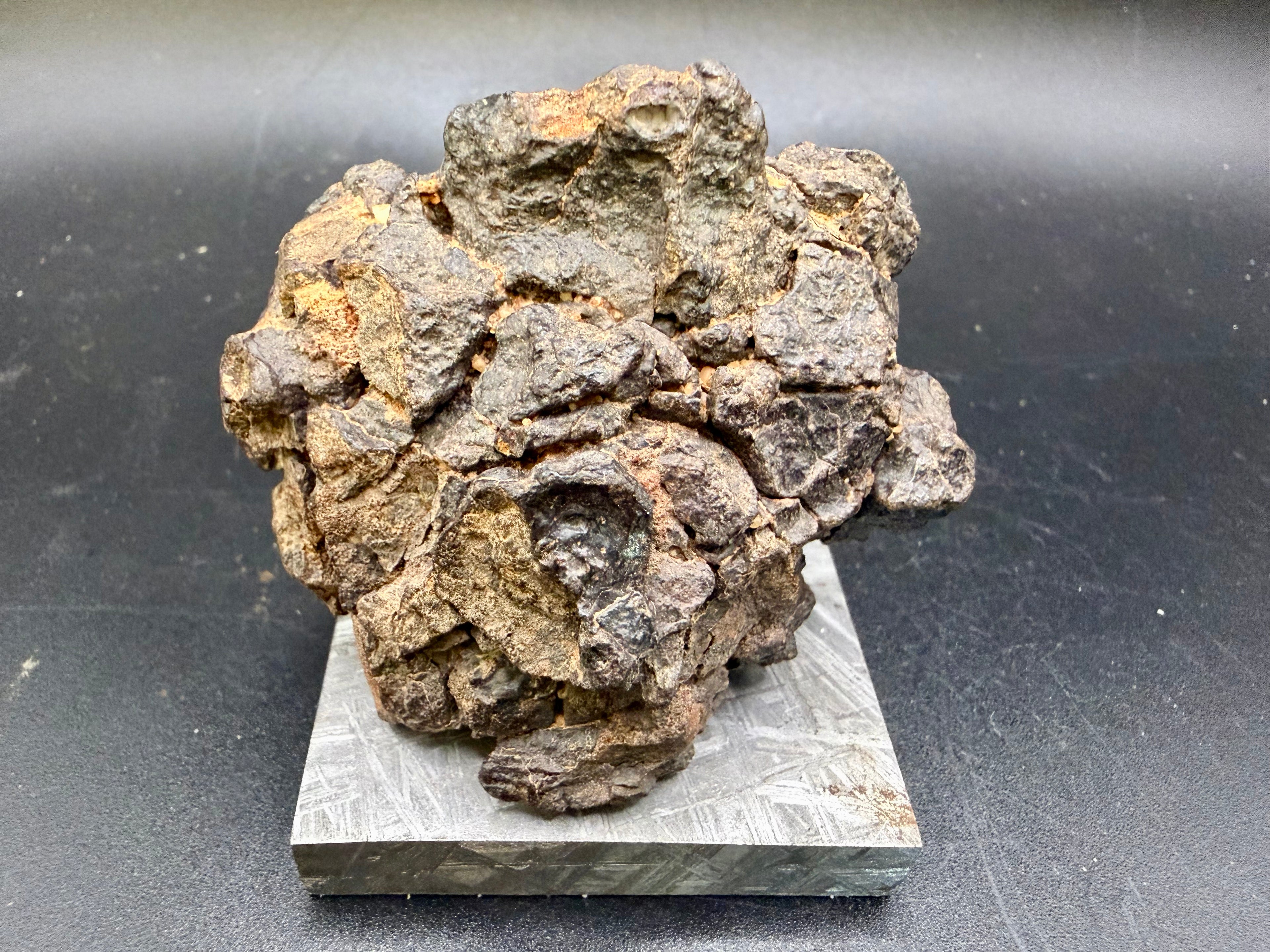 Front view of NWA 18592 Mesosiderite Meteorite showing remnant fusion crust patches and brecciated stony-iron exterior surface, 161g
