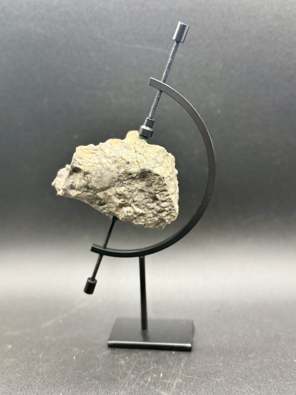 Adrar 013 lunar meteorite mounted on a display stand