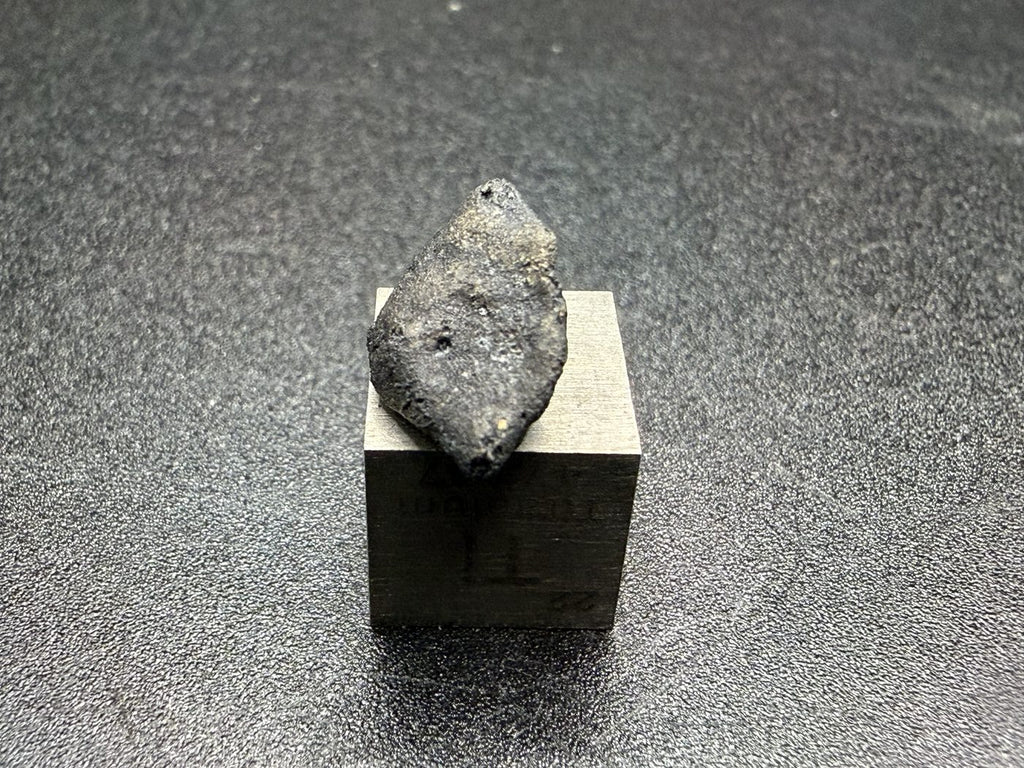 Ait Saoun EH3 meteorite, 0.67g, end view showing tapered shape and fusion crust