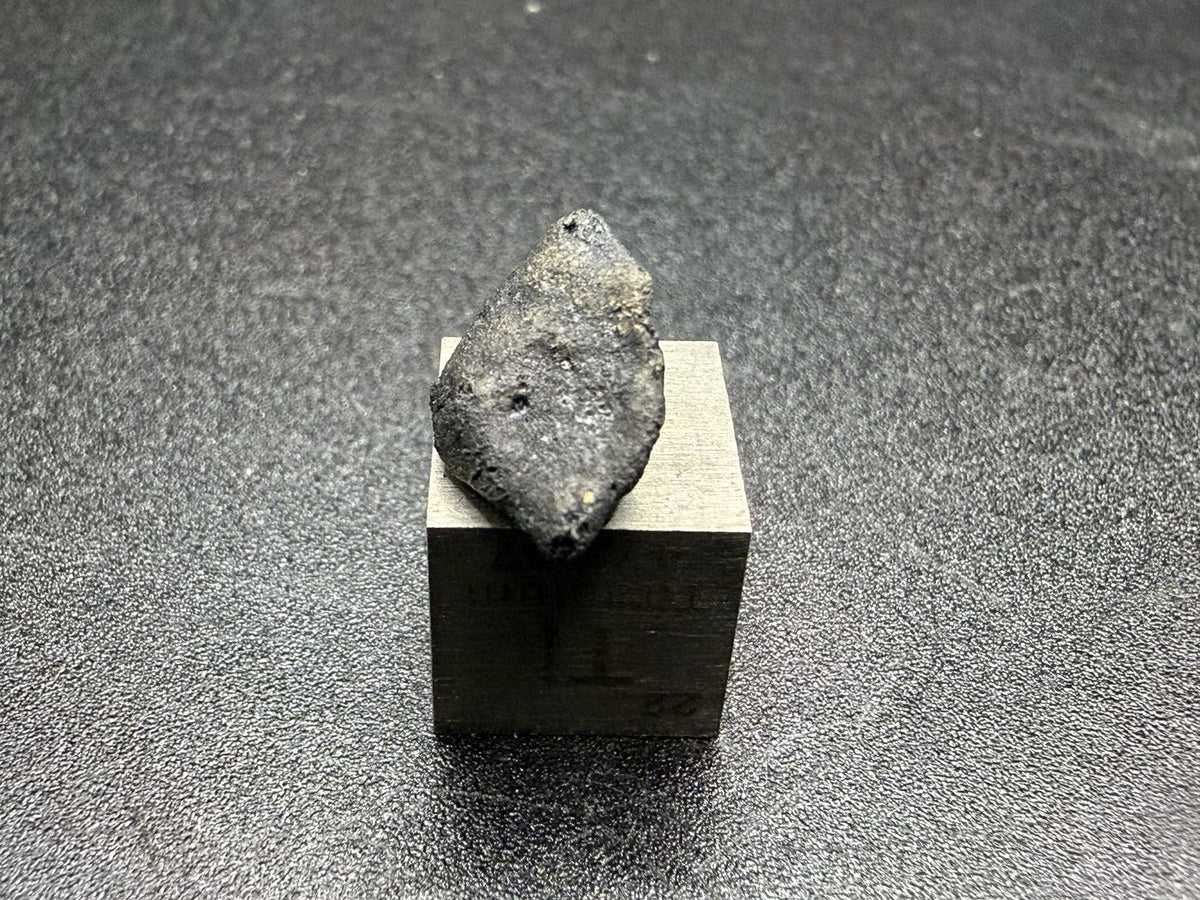 Ait Saoun EH3 meteorite, 0.67g, end view showing tapered shape and fusion crust