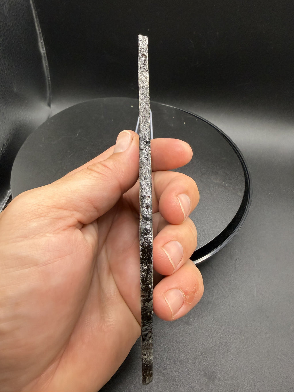 Edge profile of the 268.47g Aletai iron meteorite slice, showing thickness and natural exterior surface