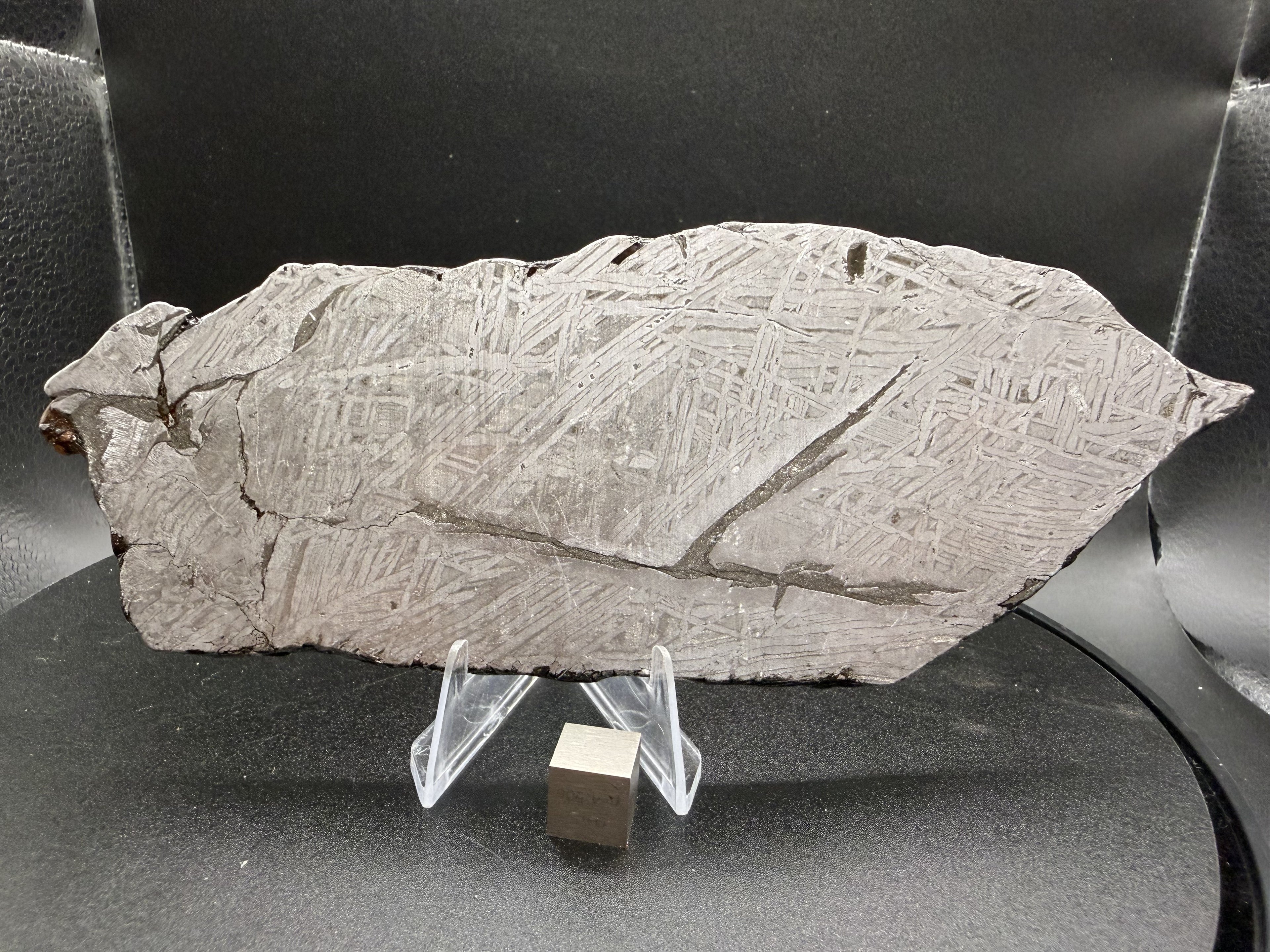 Reverse etched face of the 268.47g Aletai iron meteorite slice, Widmanstatten pattern crossed by a dark diagonal inclusion band