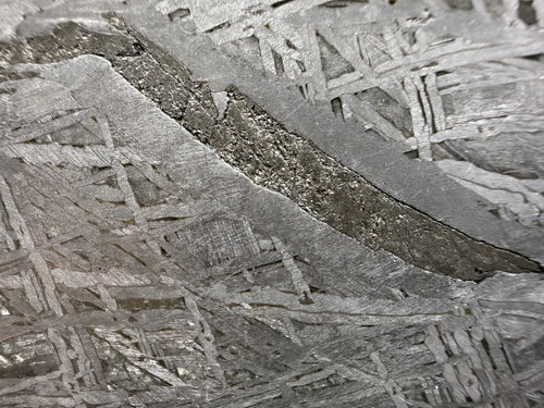 Macro of Aletai iron meteorite, Widmanstatten pattern crossed by a dark diagonal inclusion band
