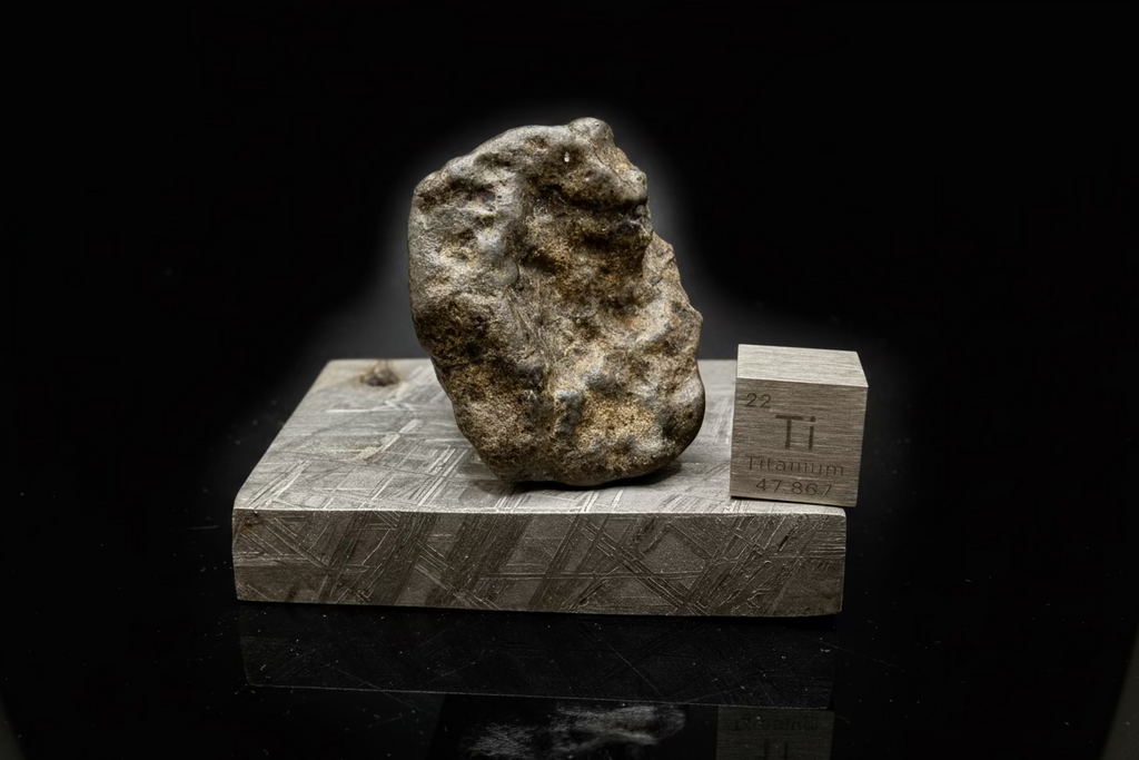 Amgala 001 Martian shergottite, left profile of 40.80g complete individual on Muonionalusta plate showing rounded thumb-printed exterior