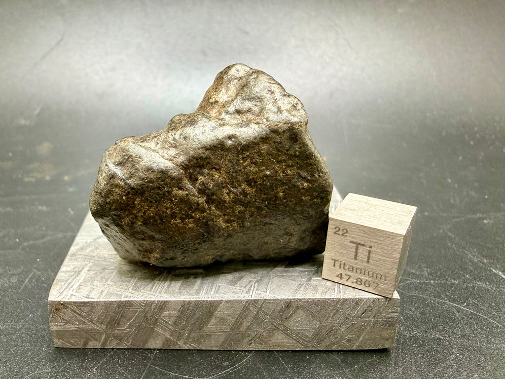 Amgala 001 Martian shergottite, rear angle of 40.80g complete individual on Muonionalusta plate with titanium scale cube