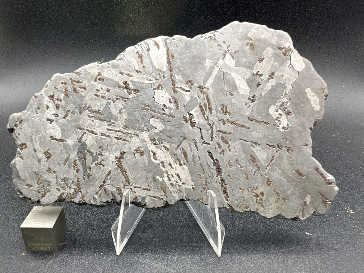 Canyon Diablo iron meteorite, IAB-MG, 112.54 g full slice on a clear acrylic stand with a scale cube, second etched face showing crossing kamacite plates and scattered bronze inclusions