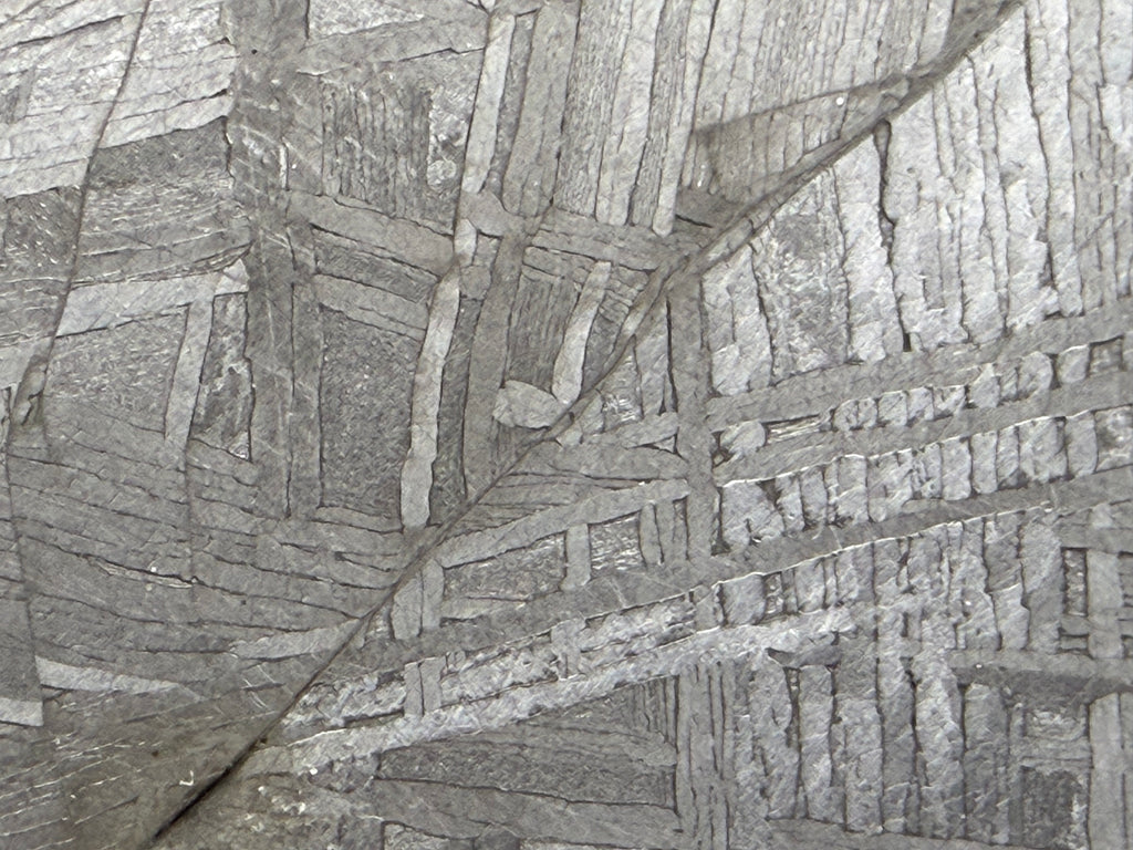 Macro view of Muonionalusta iron meteorite revealing complex Widmanstätten crystalline pattern and deformation vein