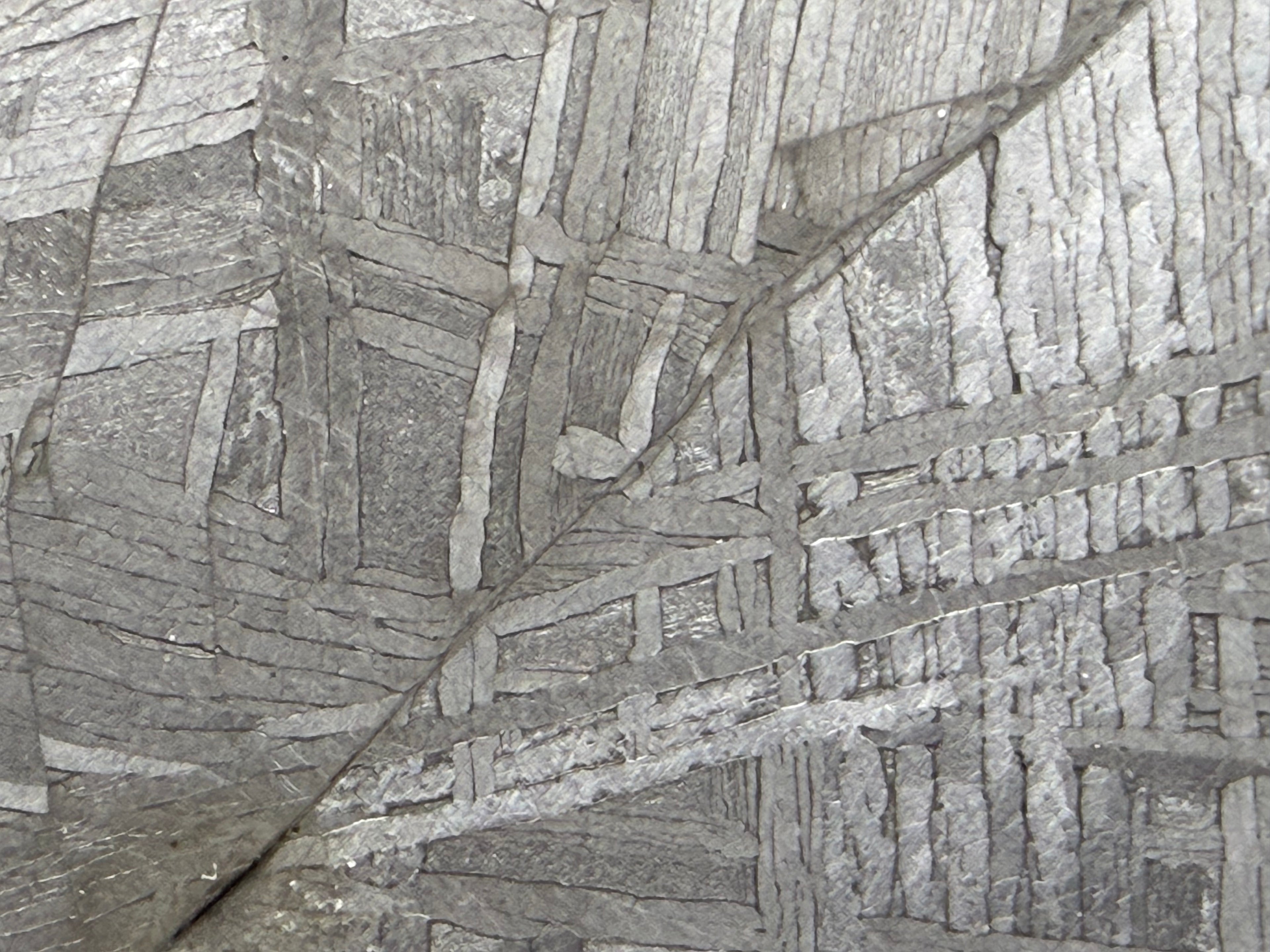 Macro view of Muonionalusta iron meteorite revealing complex Widmanstätten crystalline pattern and deformation vein