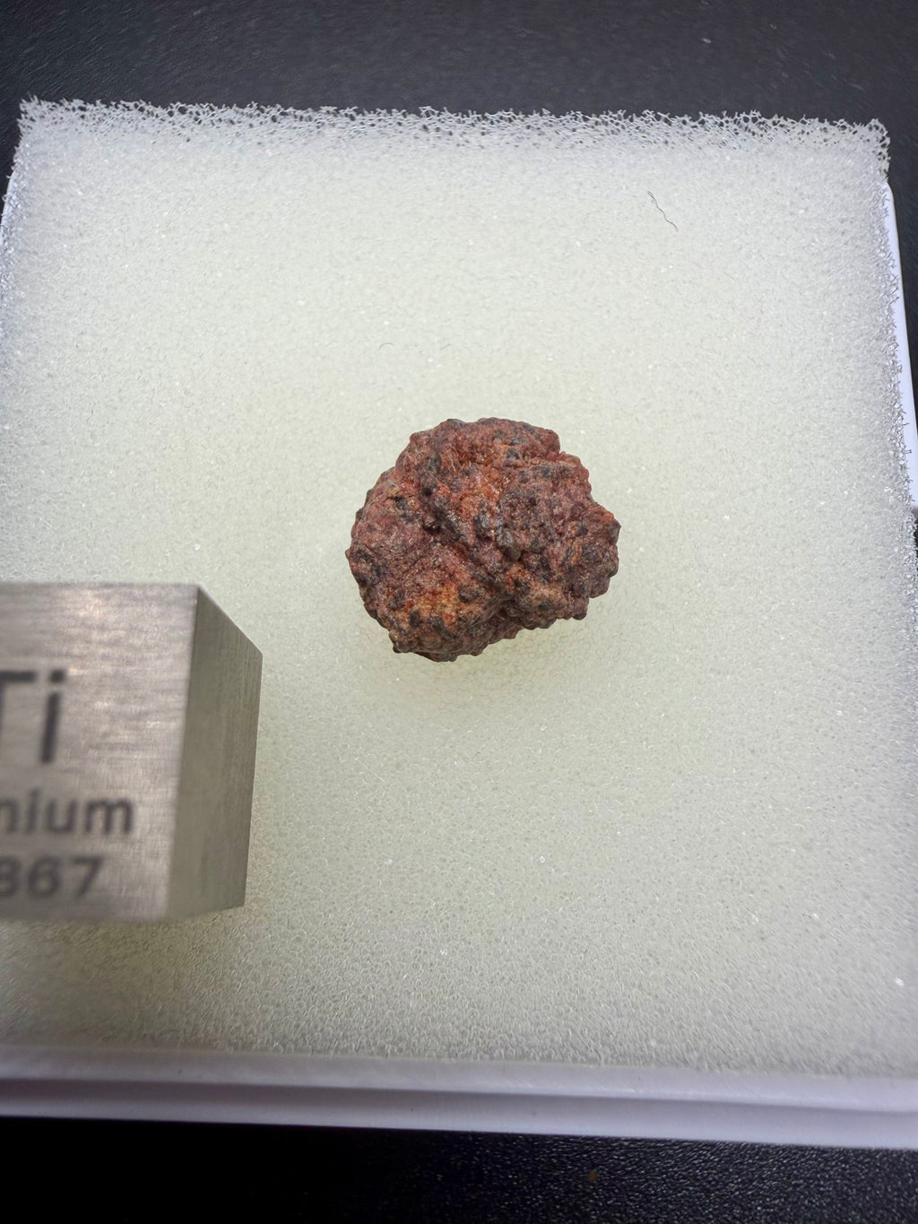 Erg Chech 002 achondrite 0.80g -- reddish-brown desert weathering staining on gray-green andesitic matrix