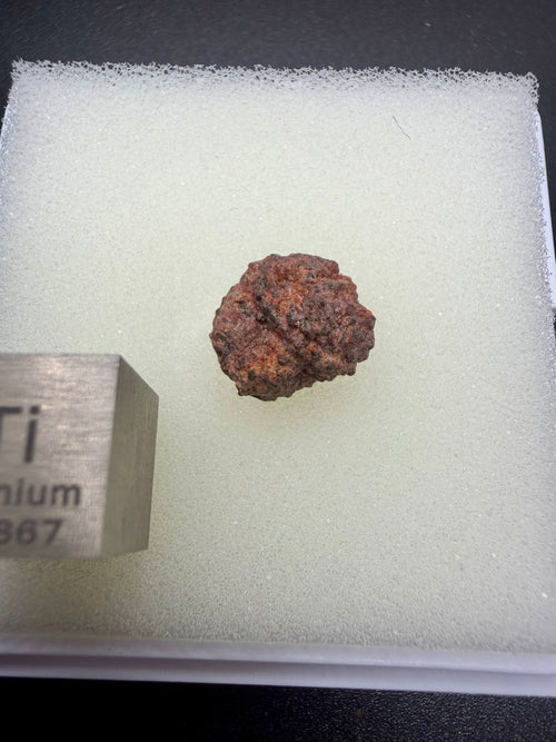 Erg Chech 002 achondrite 0.80g -- reddish-brown desert weathering staining on gray-green andesitic matrix