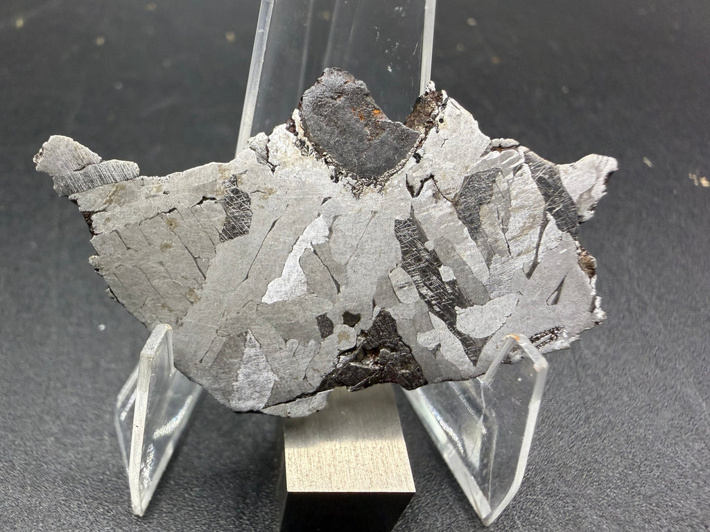 Kaalijarv iron meteorite, IAB-MG, 12.83 g slice standing upright, full etched face with crossing kamacite plates, darker zones with Neumann bands, and a large dark nodule at the top edge