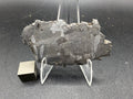 Kaalijarv iron meteorite, IAB-MG, 21.42 g slice on a clear acrylic stand with a scale cube, full view of the etched face showing the Widmanstatten pattern and weathered edges