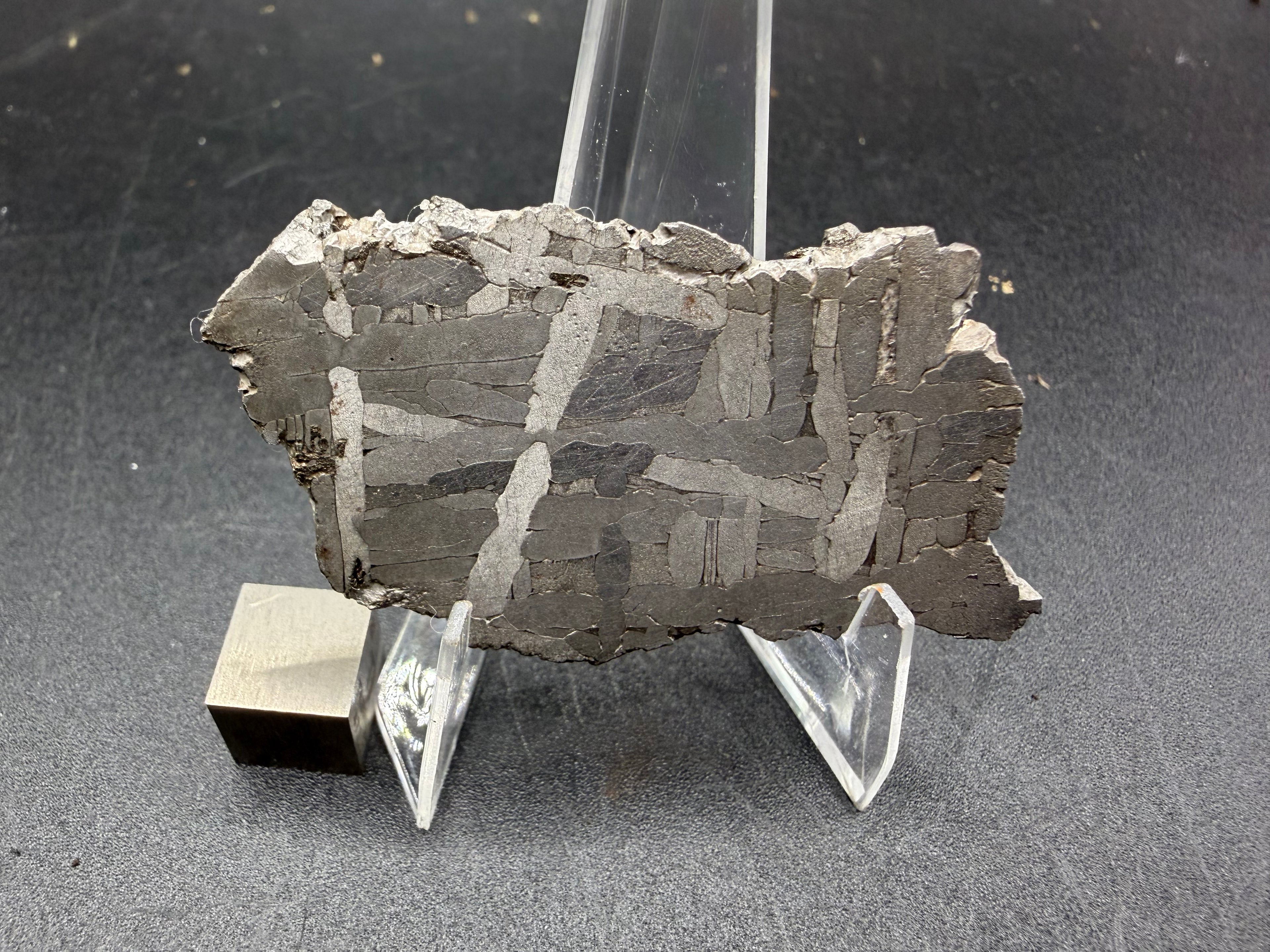 Kaalijarv iron meteorite, IAB-MG, 22.00 g slice standing upright, full etched face with bright kamacite plates crossing at angles over darker gray areas