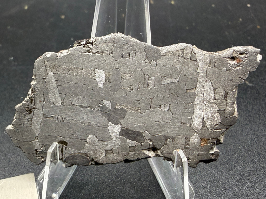 Kaalijarv iron meteorite, IAB-MG, 22.00 g slice standing upright, second etched face with crossing kamacite plates and a few bright plates against a gray background