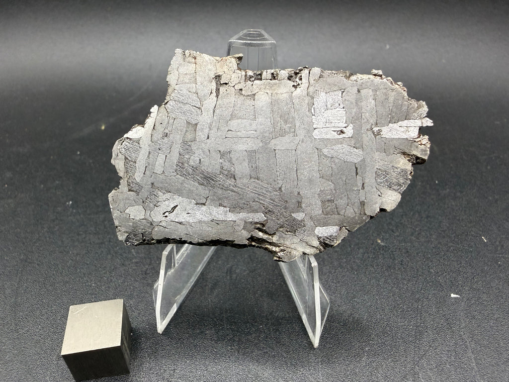 Kaalijarv iron meteorite, IAB-MG, 30.35 g slice on a clear acrylic stand with a scale cube, full view of the etched face showing crossing Widmanstatten plates