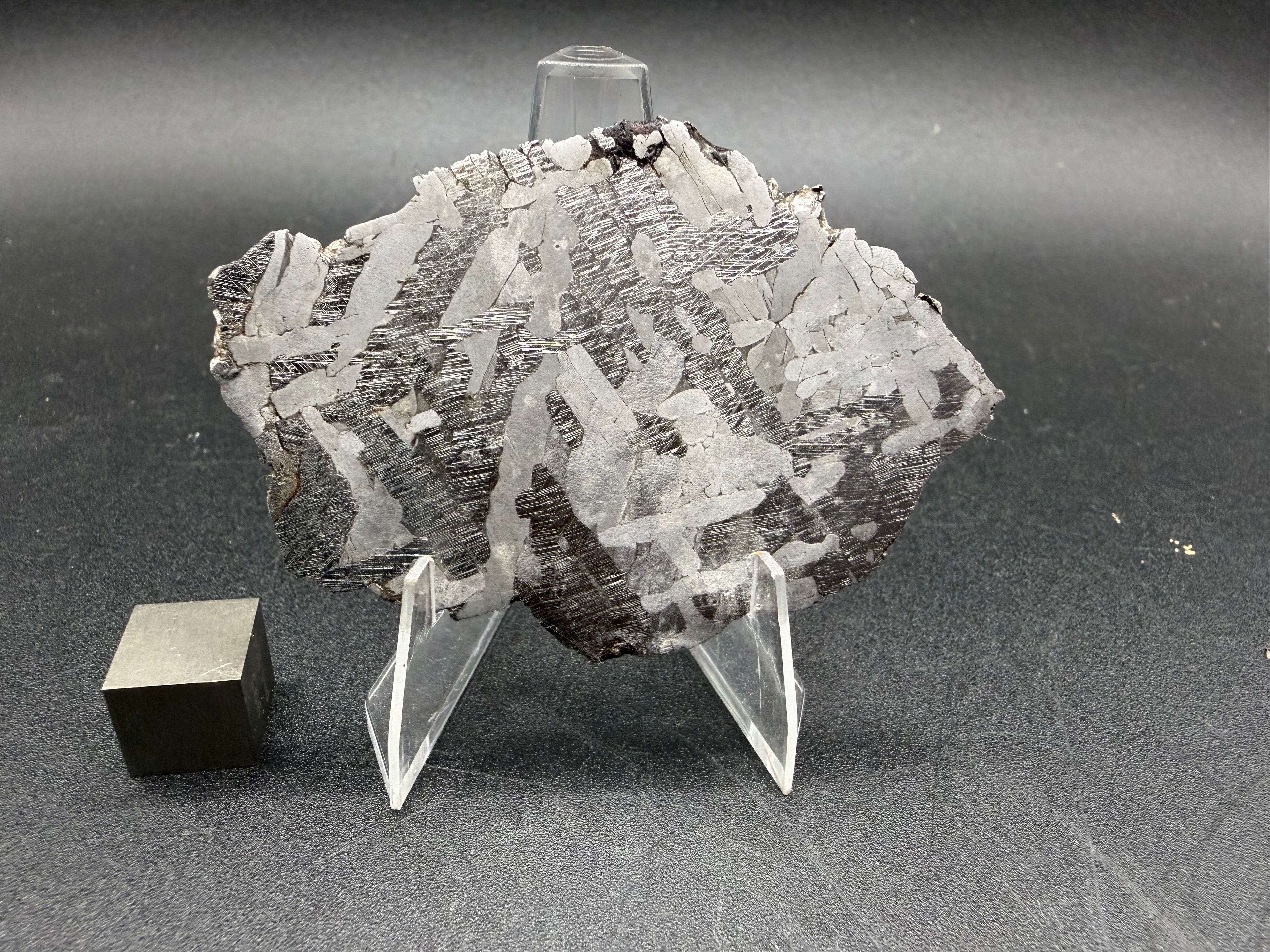Kaalijarv iron meteorite, IAB-MG, 33.88 g slice standing upright, full etched face with interlocking lighter kamacite plates and darker zones crossed by Neumann bands