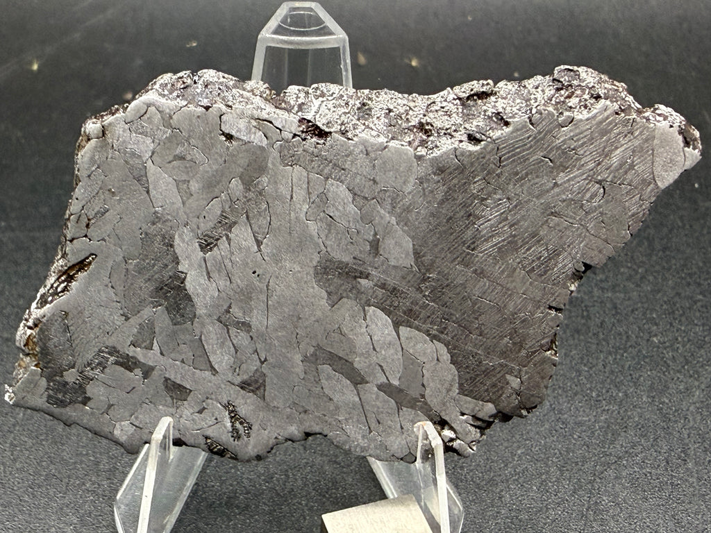Kaalijarv iron meteorite, IAB-MG, 39.28 g slice standing upright, second face with irregular kamacite crystals, a zone of dense Neumann bands at right, and weathered metal along the top edge