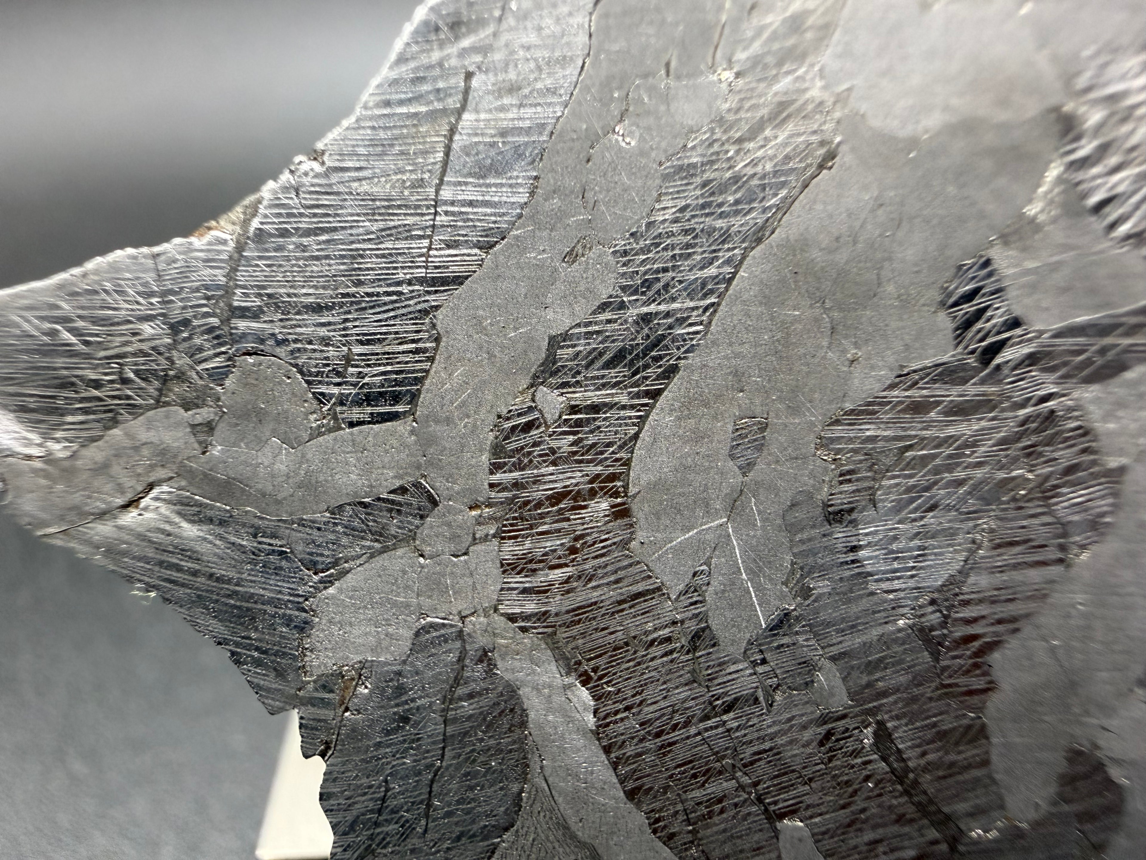 Kaalijarv iron meteorite, IAB-MG, 40.40 g slice, close-up near the edge of the etched face showing dense parallel and intersecting Neumann bands