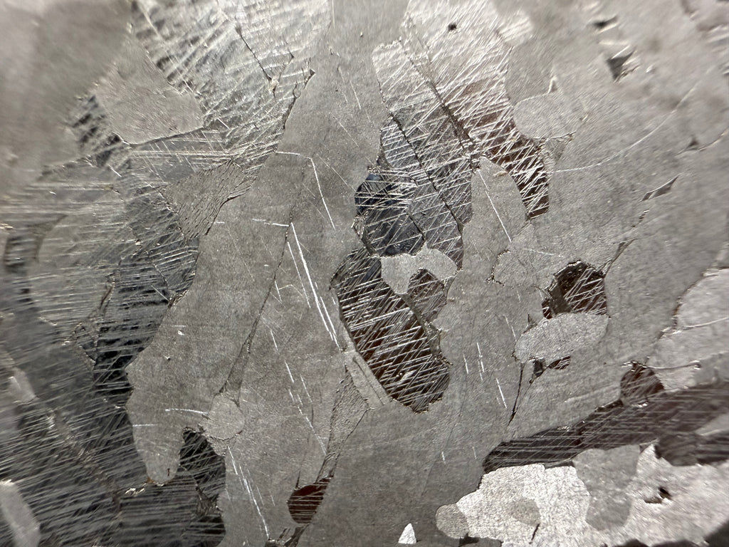 Kaalijarv iron meteorite, IAB-MG, 40.40 g slice, close-up of the etched face with intersecting Neumann bands in darker zones between lighter, smoother crystal areas