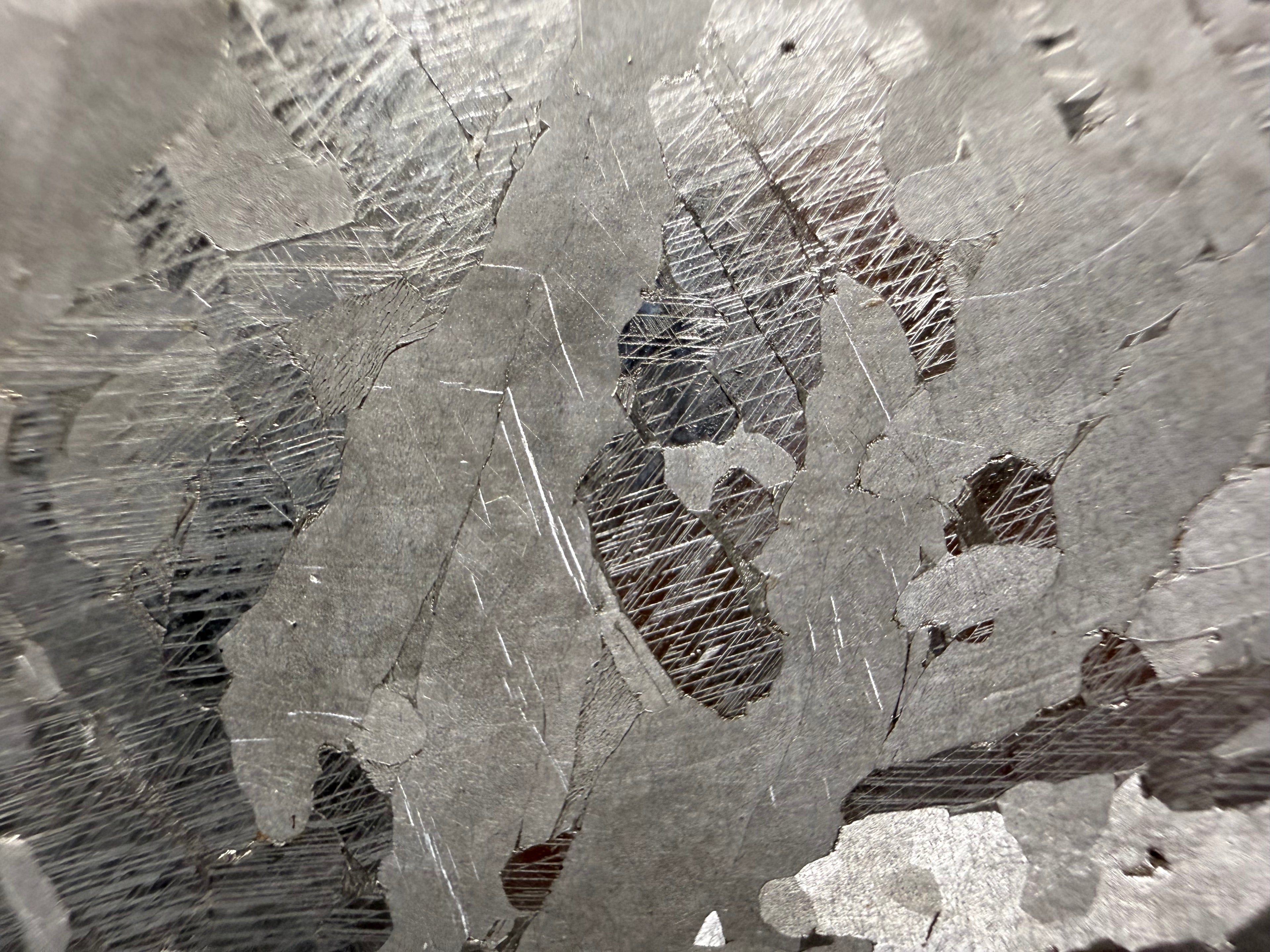 Kaalijarv iron meteorite, IAB-MG, 40.40 g slice, close-up of the etched face with intersecting Neumann bands in darker zones between lighter, smoother crystal areas