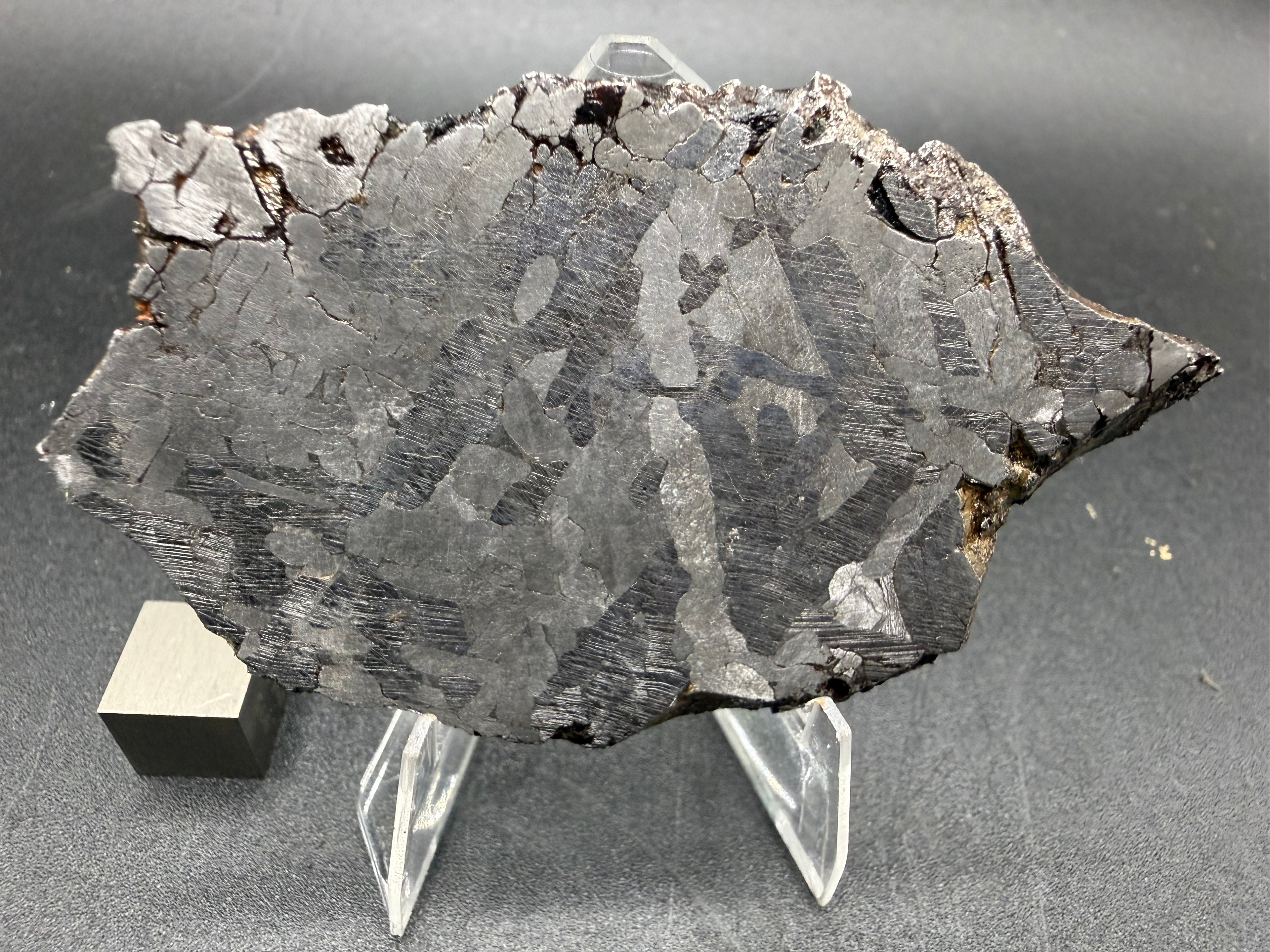 Kaalijarv iron meteorite, IAB-MG, 40.40 g slice standing upright, second etched face with lighter crystal zones and darker areas crossed by Neumann bands