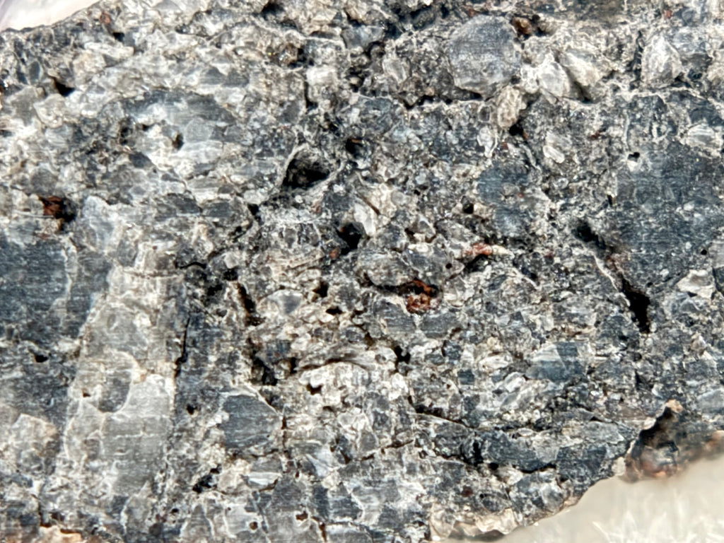 Macro view of Ksar Ghilane 022 ungrouped achondrite meteorite slice showing equant augite crystal matrix with minor enstatite grains, 1.75g