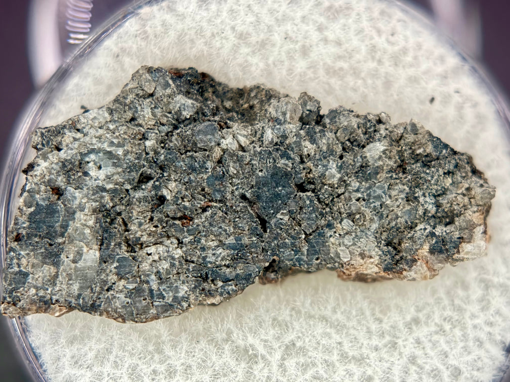 Full slice of Ksar Ghilane 022 ungrouped achondrite meteorite showing secondary calcite veining crossing pyroxene-dominated texture, 1.75g