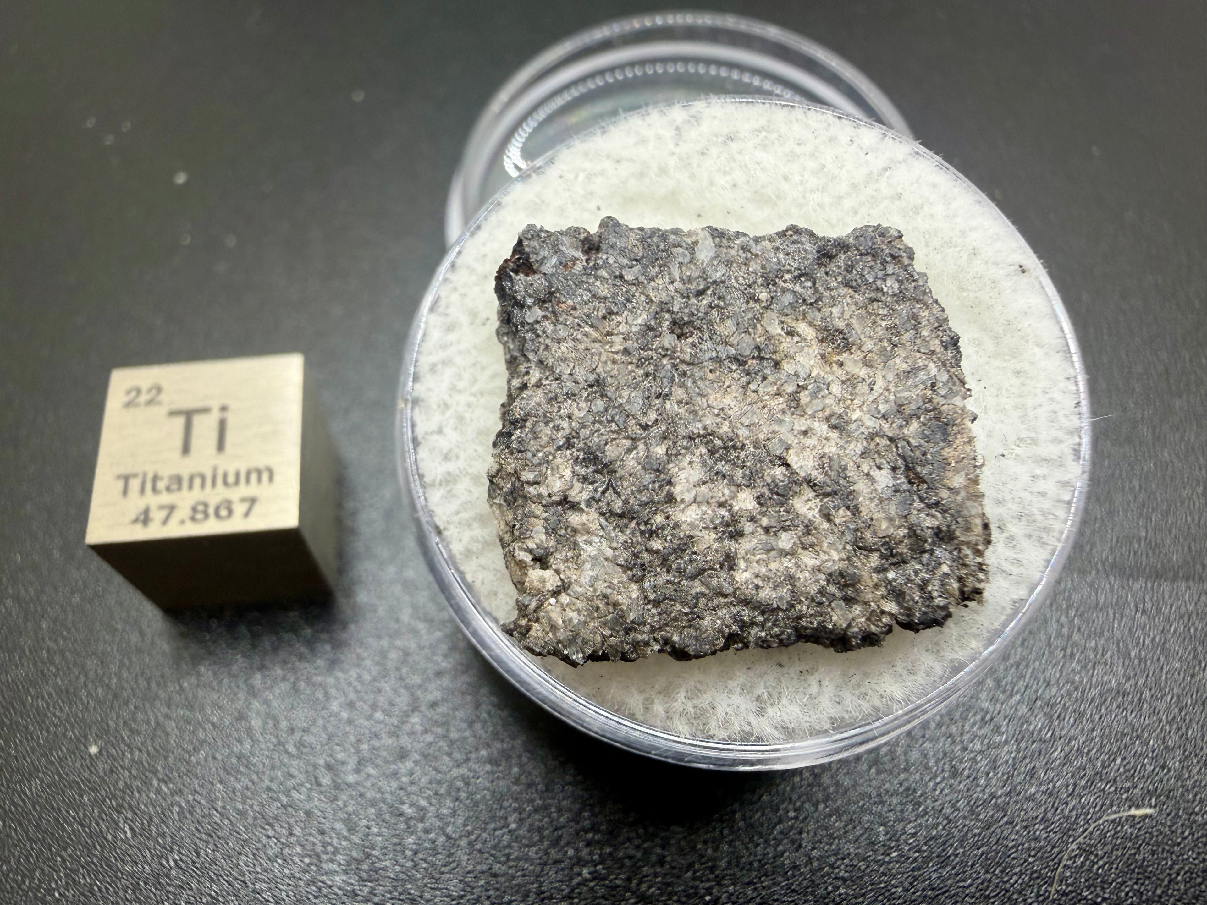 Top view of Ksar Ghilane 022 ungrouped achondrite meteorite slice showing secondary calcite veining cutting primary igneous texture, 2.33g