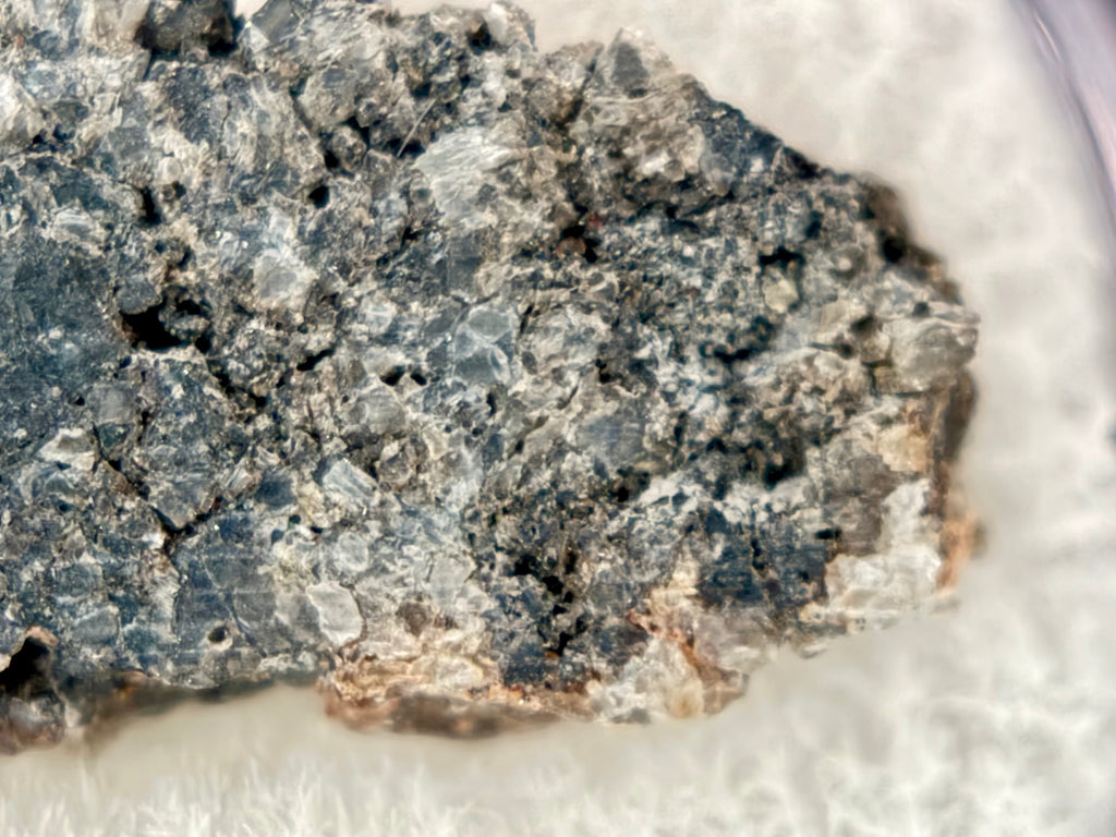 Closeup of Ksar Ghilane 022 ungrouped achondrite meteorite slice showing granular fabric with 1.5 mm augite crystals and sulfide inclusions, 1.75g