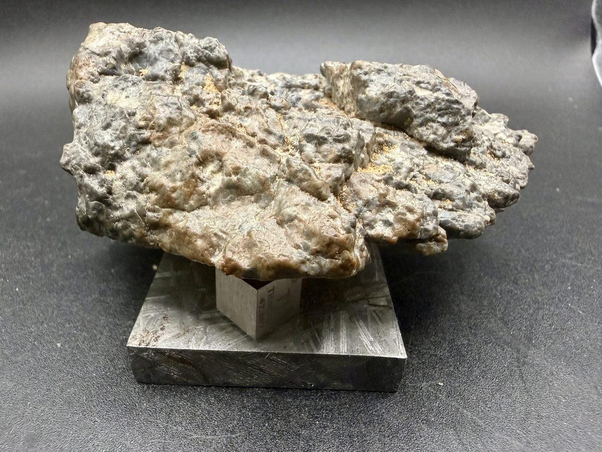Side view of the Laayoune 002 lunar meteorite individual with a scale cube
