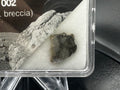 Laâyoune 002 lunar meteorite slice in small display box close-up