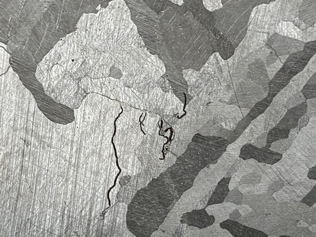 Mount Dooling iron meteorite, IC, 105.76 g slice, close-up of the polished and etched face showing kamacite plates, grain boundaries and fine dark wavy lines