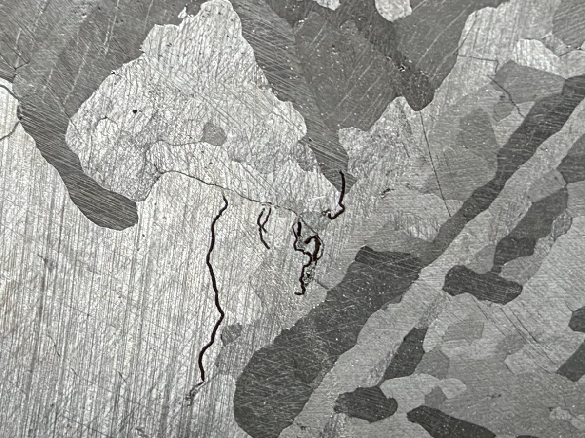 Mount Dooling iron meteorite, IC, 105.76 g slice, close-up of the polished and etched face showing kamacite plates, grain boundaries and fine dark wavy lines