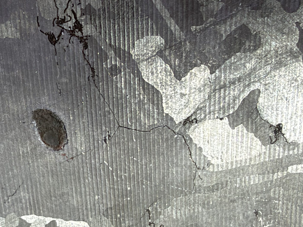 Mount Dooling iron meteorite, IC, 105.76 g slice, close-up of the reverse wire sawn and etched face showing fine saw lines over the etched pattern beside the dark inclusion
