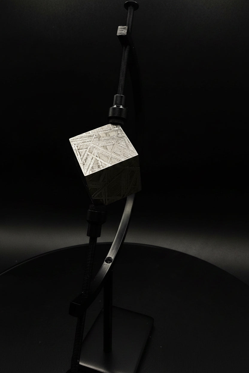 Close up of Muonionalusta iron meteorite cube on display stand showing fine octahedrite etch pattern, 65g