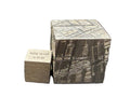 Side profile of Muonionalusta IVA fine octahedrite cube showing etched kamacite bands beside density reference cube, 65g
