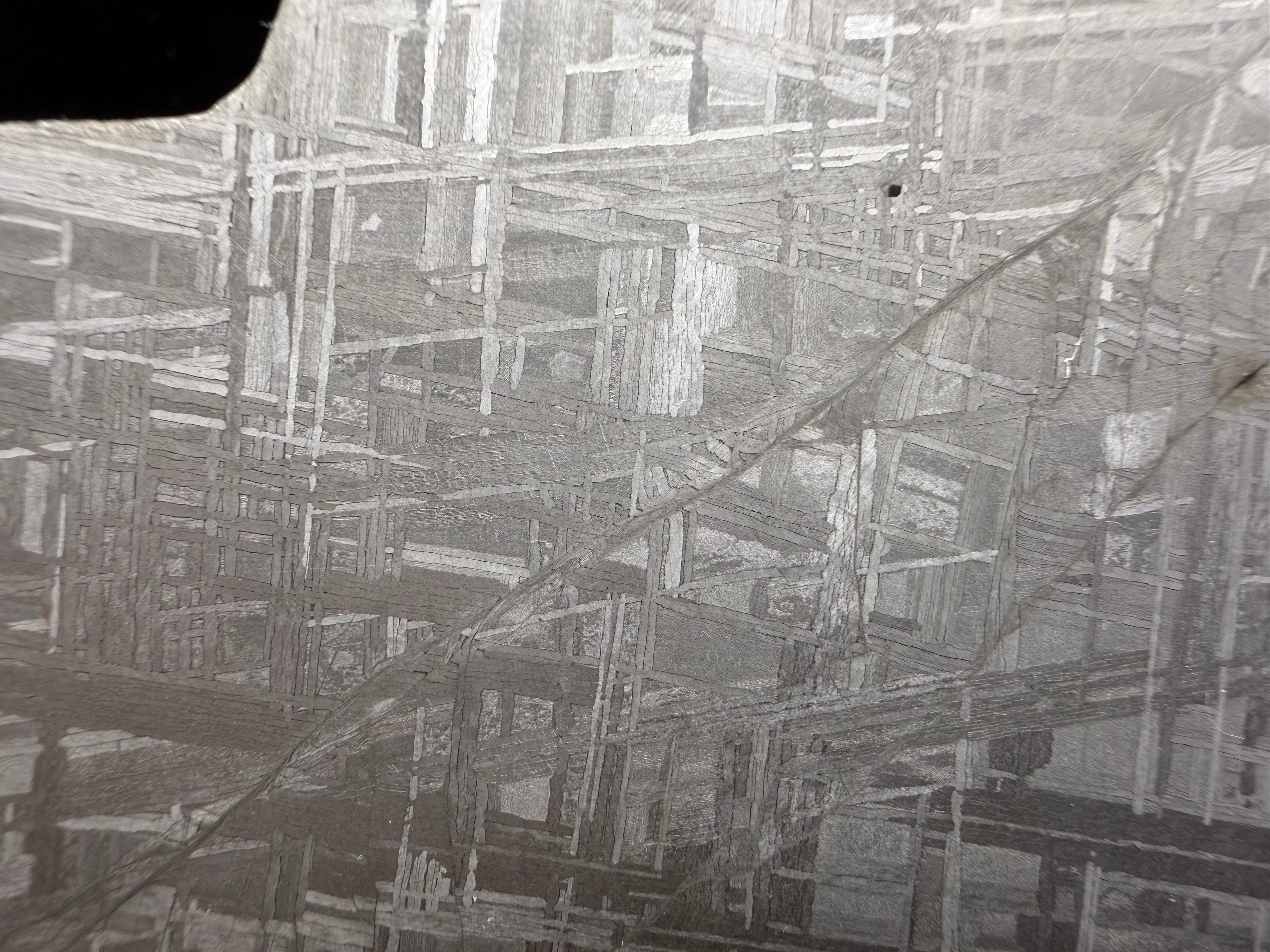Close-up of etched Muonionalusta iron meteorite showing Widmanstätten pattern formed during slow cooling inside a planetary core.