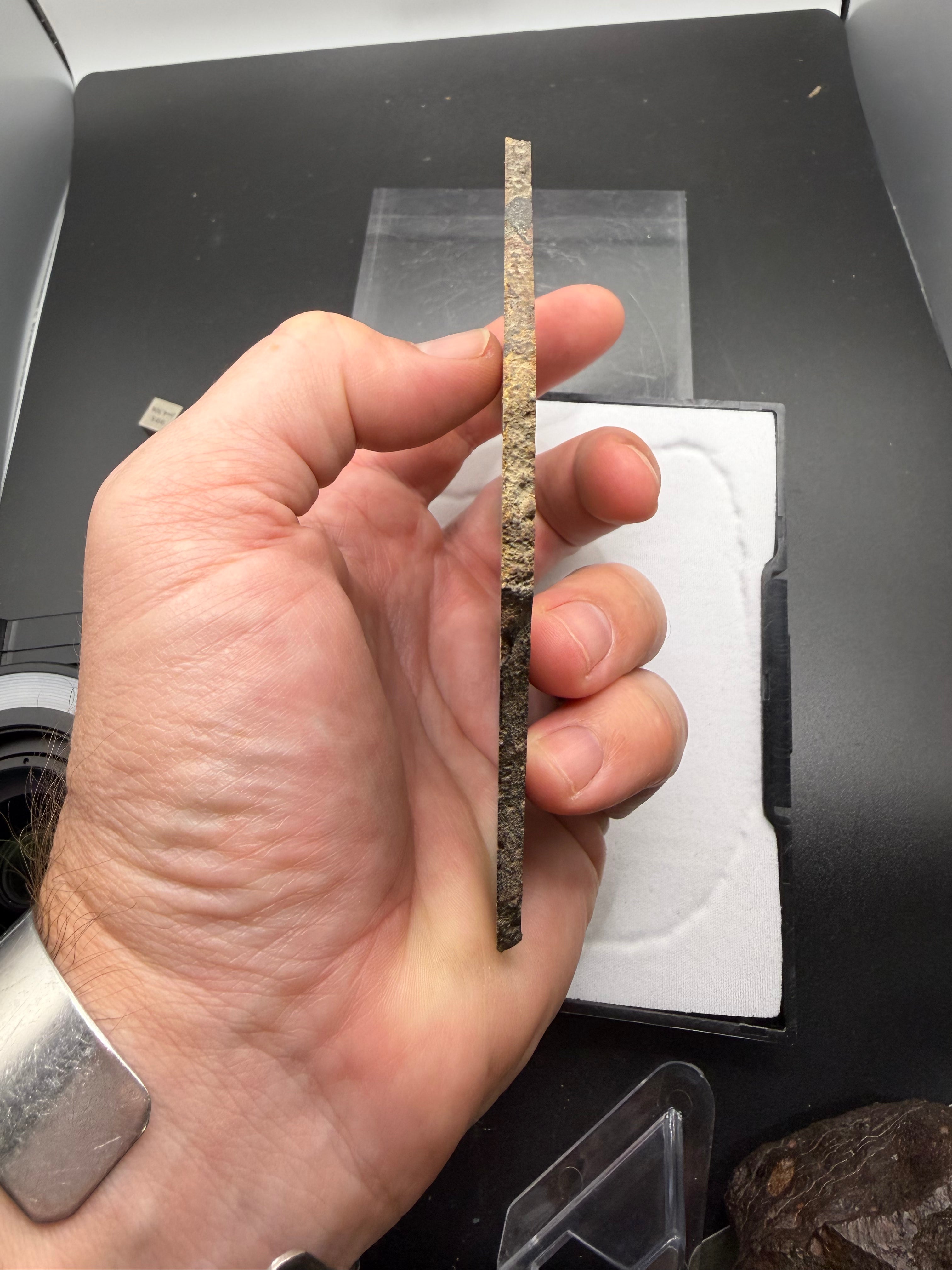 Hand-held scale reference of NWA 16120 LL3 ordinary chondrite meteorite slice