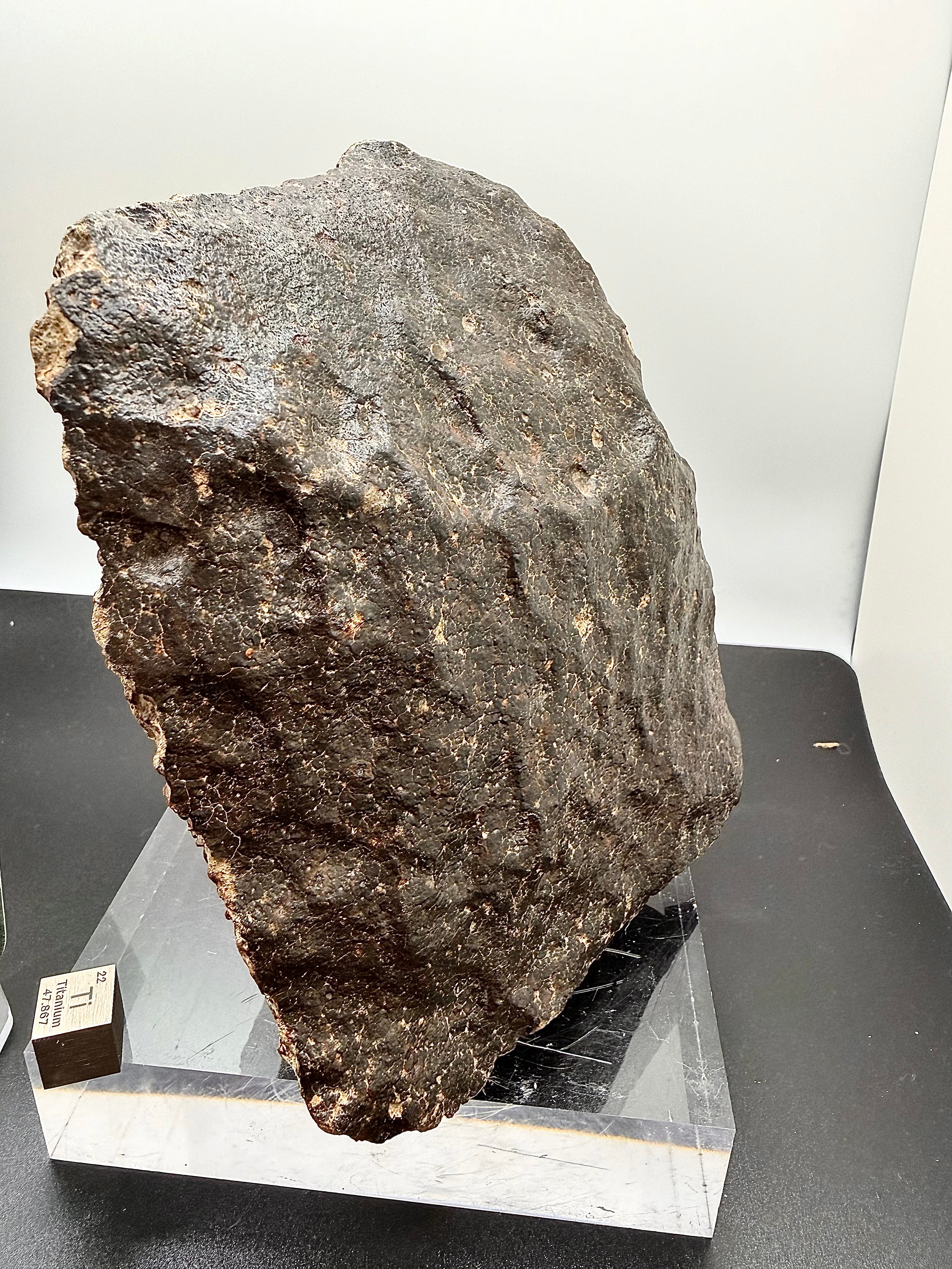 Side view of NWA 17296 L5 Ordinary Chondrite Meteorite showing complete oriented stone with small cut window exposing chondrule structure in L5 matrix, 1472.00g