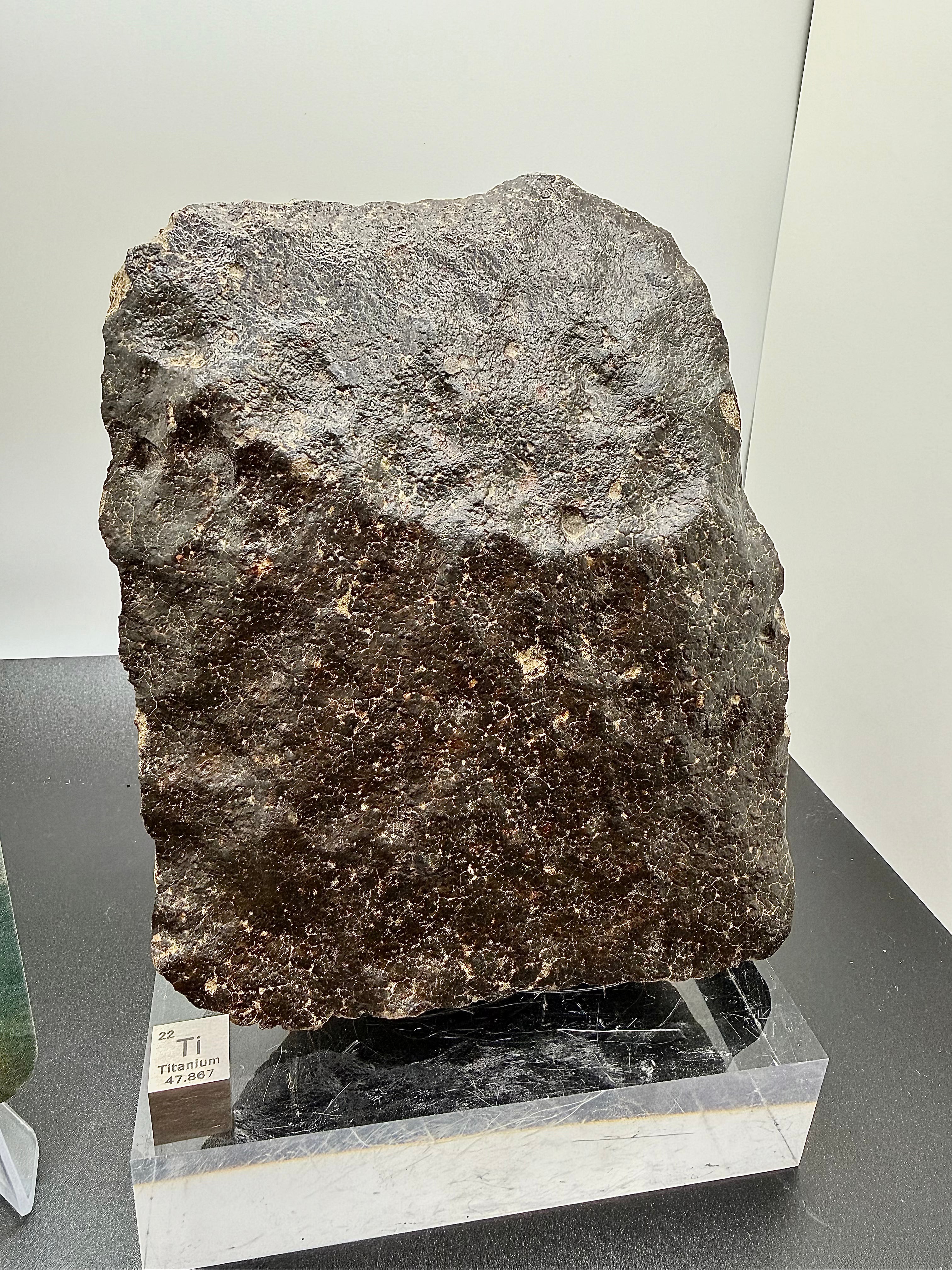 Side view of NWA 17296 L5 Ordinary Chondrite Meteorite showing pronounced regmaglypt depressions from atmospheric ablation with titanium scale element, 1472.00g